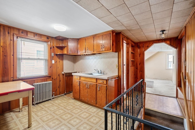46-27 195th St, Flushing, NY 11358 - kitchen featuring radiator heating unit, healthy amount of natural light, brown cabinets, and wooden walls