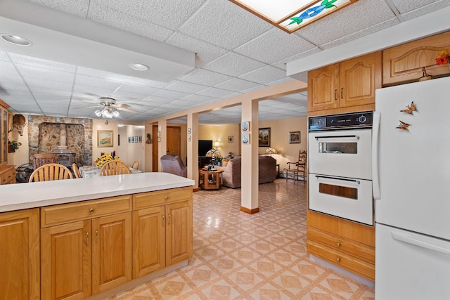 41-59 Fox Mountain Rd, Livingston Manor, NY 12758 - kitchen featuring white appliances, a drop ceiling, light countertops, a wood stove, and ceiling fan
