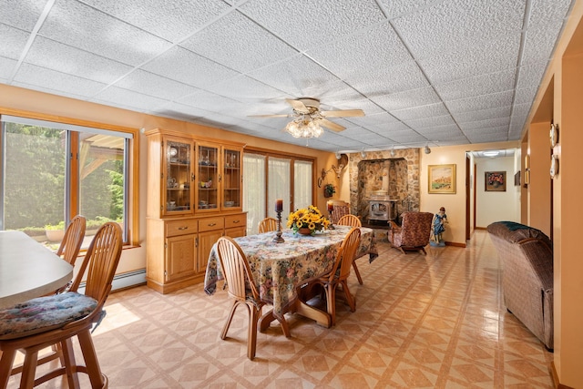 41-59 Fox Mountain Rd, Livingston Manor, NY 12758 - dining space with a wood stove, a paneled ceiling, light flooring, a baseboard heating unit, and plenty of natural light