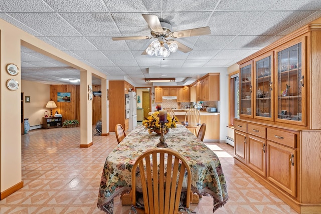 41-59 Fox Mountain Rd, Livingston Manor, NY 12758 - dining space with a ceiling fan, a paneled ceiling, light floors, a baseboard heating unit, and wooden walls