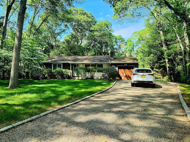 49 Sayres Path, Wainscott, NY 11975 - view of front of house with driveway, an attached garage, a chimney, and a front yard