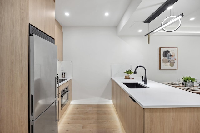 168 E 111th St Unit 8B, New York Manhattan, NY 10029 - kitchen featuring appliances with stainless steel finishes, modern cabinets, light brown cabinets, a peninsula, and recessed lighting