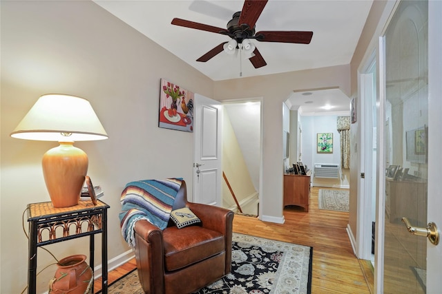 6404 78th St, Middle Village, NY 11379 - living area featuring wood finished floors, arched walkways, ceiling fan, and an AC wall unit