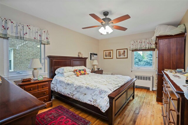 6404 78th St, Middle Village, NY 11379 - bedroom with radiator, light wood-style floors, and a ceiling fan