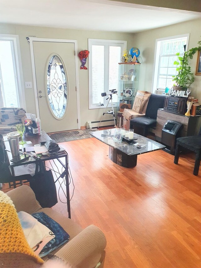 12826 Gotham Rd, South Ozone Park, NY 11420 - living area featuring wood finished floors, plenty of natural light, and baseboard heating