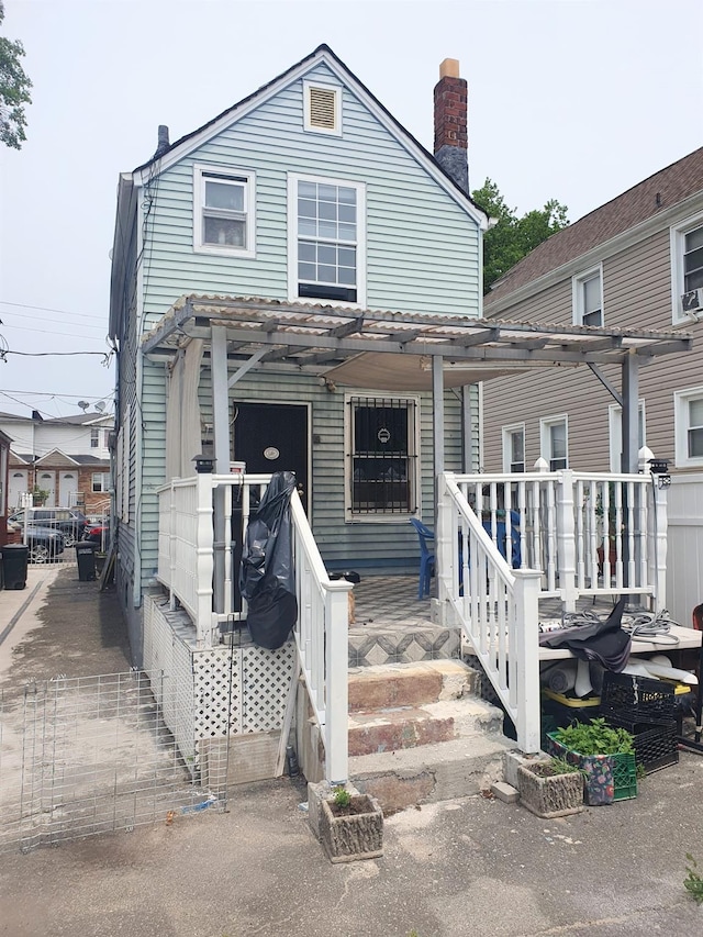 12826 Gotham Rd, South Ozone Park, NY 11420 - view of front facade with a chimney and a pergola