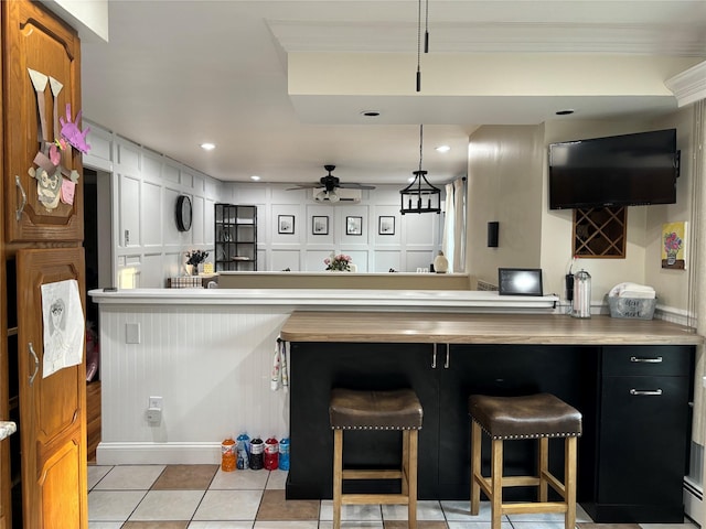 179 Clinton Ave, East Patchogue, NY 11772 - kitchen with a ceiling fan, crown molding, a kitchen bar, light tile patterned floors, and recessed lighting