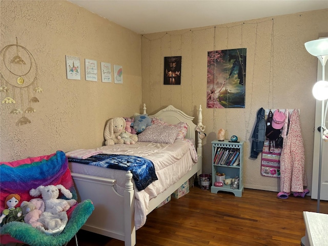 179 Clinton Ave, East Patchogue, NY 11772 - bedroom featuring a textured wall and wood finished floors