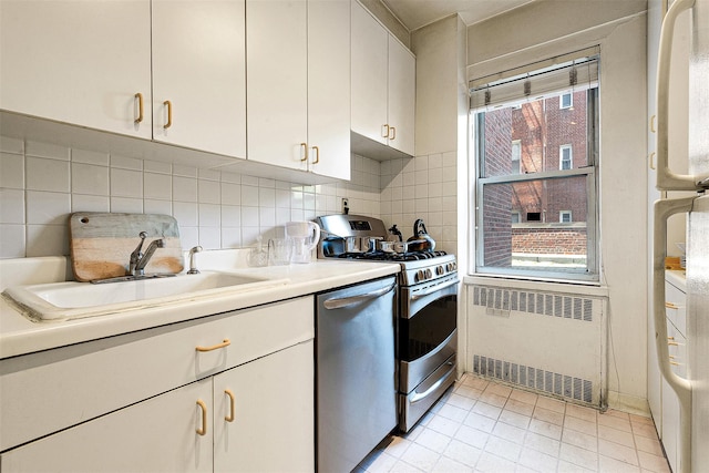 69-10 108th St Unit 1N, Forest Hills, NY 11375 - kitchen with appliances with stainless steel finishes, radiator, white cabinetry, and backsplash