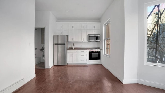 1823 Anthony Ave, Bronx, NY 10457 - kitchen featuring stainless steel appliances, a baseboard heating unit, white cabinets, and dark wood-type flooring