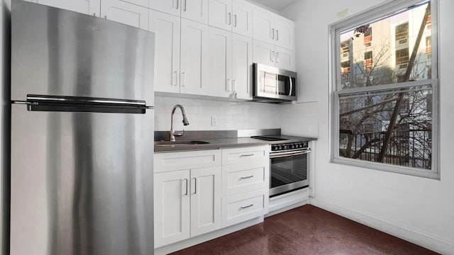 1823 Anthony Ave, Bronx, NY 10457 - kitchen featuring stainless steel appliances, white cabinetry, decorative backsplash, dark countertops, and dark wood-style flooring