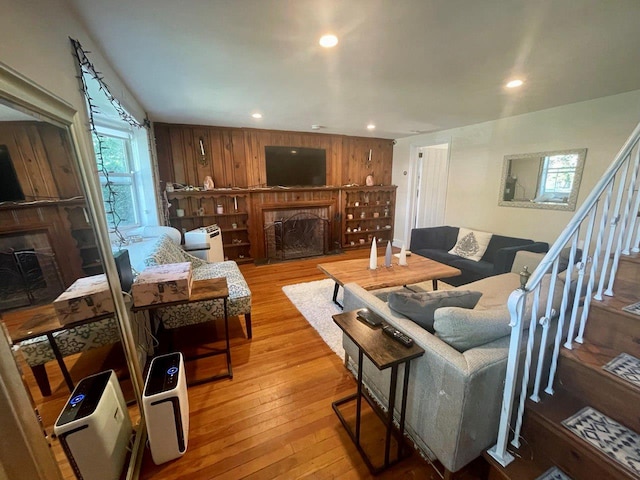 390 Atlantic Ave, East Rockaway, NY 11518 - living area with a fireplace, hardwood / wood-style flooring, recessed lighting, stairs, and wooden walls
