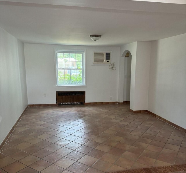 390 Atlantic Ave, East Rockaway, NY 11518 - tiled empty room with radiator heating unit, an AC wall unit, and arched walkways