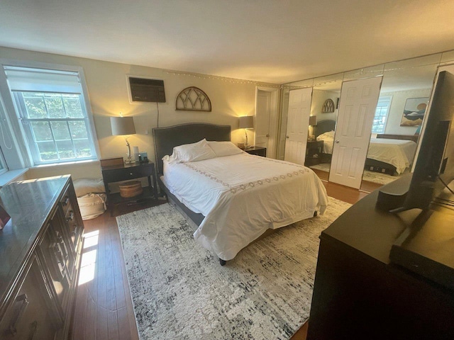 390 Atlantic Ave, East Rockaway, NY 11518 - bedroom with wood finished floors, multiple windows, and a wall mounted AC