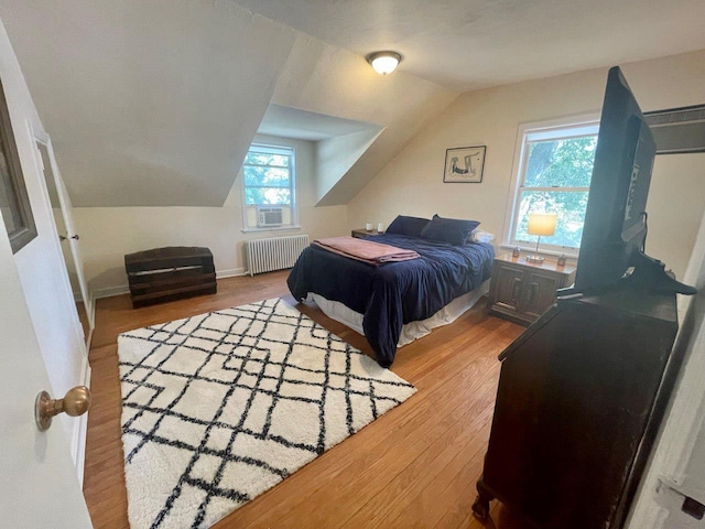 390 Atlantic Ave, East Rockaway, NY 11518 - bedroom featuring radiator heating unit, wood finished floors, and lofted ceiling