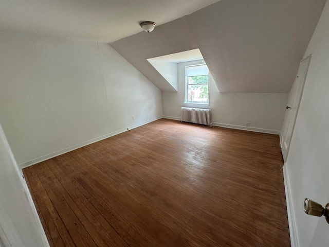 390 Atlantic Ave, East Rockaway, NY 11518 - additional living space with radiator heating unit, wood finished floors, and vaulted ceiling