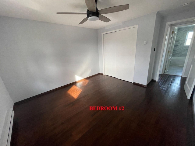 390 Atlantic Ave, East Rockaway, NY 11518 - unfurnished bedroom featuring dark wood-type flooring, baseboard heating, ceiling fan, and a closet