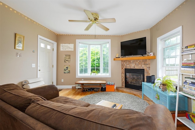 10 Tobacco Ln, Red Hook, NY 12571 - living area featuring wood finished floors, a glass covered fireplace, and ceiling fan