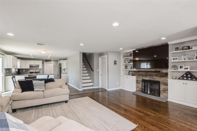 393 S 4th St, Lindenhurst, NY 11757 - living area with stairs, dark wood finished floors, recessed lighting, and a fireplace