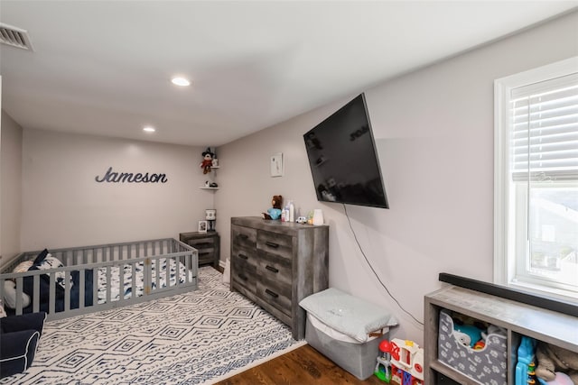 393 S 4th St, Lindenhurst, NY 11757 - bedroom featuring a nursery area, recessed lighting, and wood finished floors