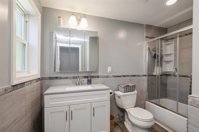 393 S 4th St, Lindenhurst, NY 11757 - full bath with tile walls, vanity, wainscoting, and bath / shower combo with glass door