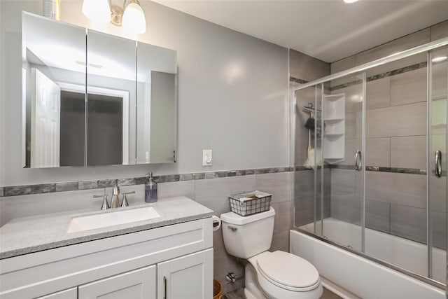 393 S 4th St, Lindenhurst, NY 11757 - full bath featuring vanity, bath / shower combo with glass door, a wainscoted wall, and tile walls