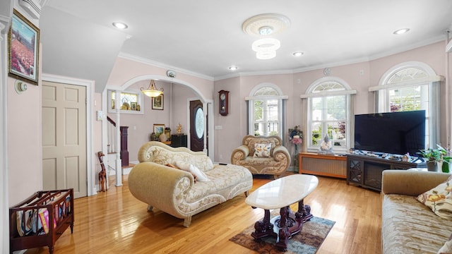 89-10 189th St, Hollis, NY 11423 - living room featuring light wood-style floors, healthy amount of natural light, arched walkways, crown molding, and stairs