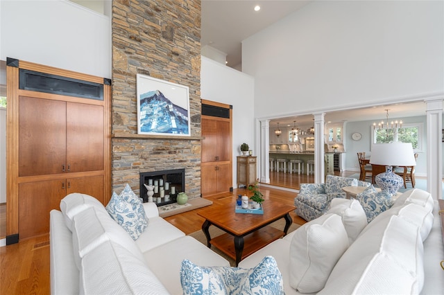 4510 Peconic Bay Blvd, Laurel, NY 11948 - living area with wood finished floors, ornate columns, a fireplace, a high ceiling, and recessed lighting