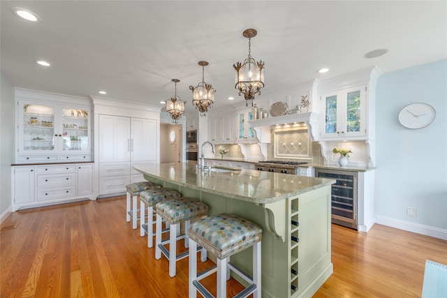 4510 Peconic Bay Blvd, Laurel, NY 11948 - kitchen featuring wine cooler, white cabinetry, a chandelier, light wood-style floors, and recessed lighting