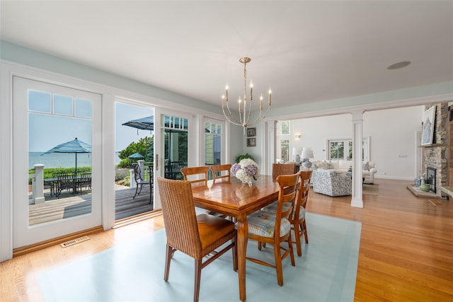 4510 Peconic Bay Blvd, Laurel, NY 11948 - dining space with a chandelier, light wood-type flooring, and a fireplace