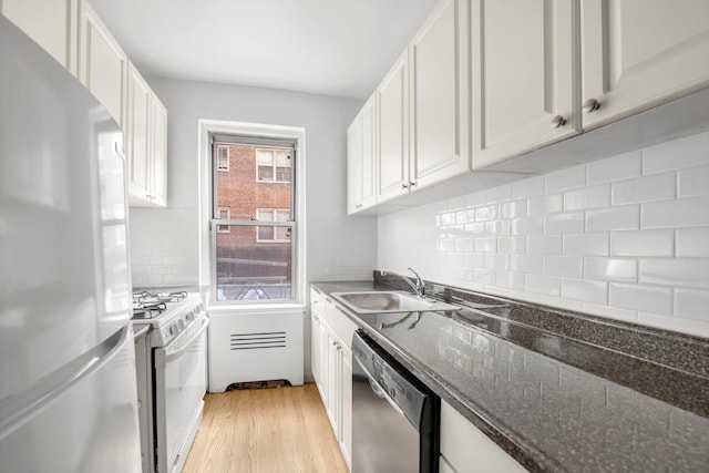 63-60 102nd St Unit A8, Rego Park, NY 11374 - kitchen featuring fridge, dishwasher, gas range gas stove, light wood-style floors, and white cabinetry