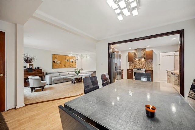 213-09 64th Ave, Oakland Gardens, NY 11364 - kitchen with wall chimney range hood, appliances with stainless steel finishes, decorative backsplash, light wood-type flooring, and recessed lighting
