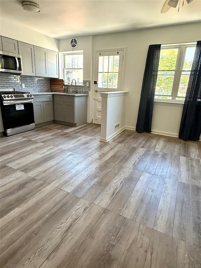 1319 Hicks St, Bronx, NY 10469 - kitchen with appliances with stainless steel finishes, gray cabinetry, light wood-style floors, and a ceiling fan