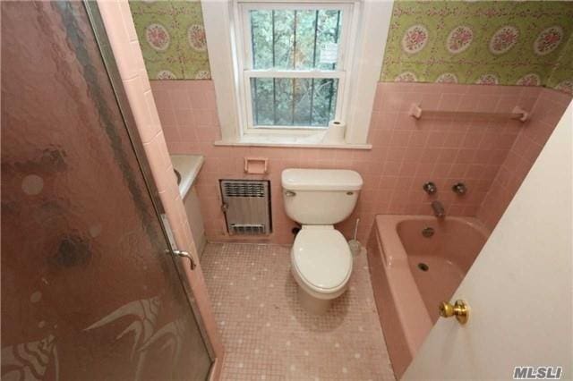 85-24 Eton St, Jamaica Estates, NY 11432 - bathroom with radiator heating unit, a garden tub, tile patterned flooring, tile walls, and a shower with door