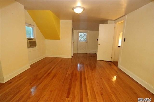 85-24 Eton St, Jamaica Estates, NY 11432 - bonus room with baseboard heating, wood finished floors, and cooling unit