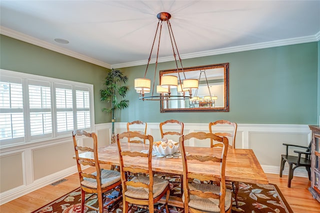 122 Cambon Ave, Saint James, NY 11780 - dining room featuring light wood finished floors, crown molding, wainscoting, and a chandelier
