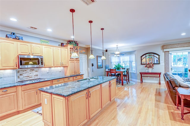 122 Cambon Ave, Saint James, NY 11780 - kitchen with stainless steel appliances, light wood-type flooring, crown molding, tasteful backsplash, and dark stone countertops
