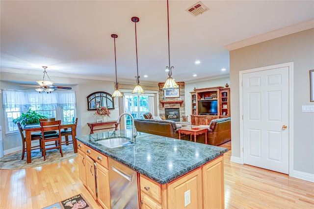 122 Cambon Ave, Saint James, NY 11780 - kitchen featuring light brown cabinets, light wood-type flooring, a stone fireplace, ceiling fan, and ornamental molding