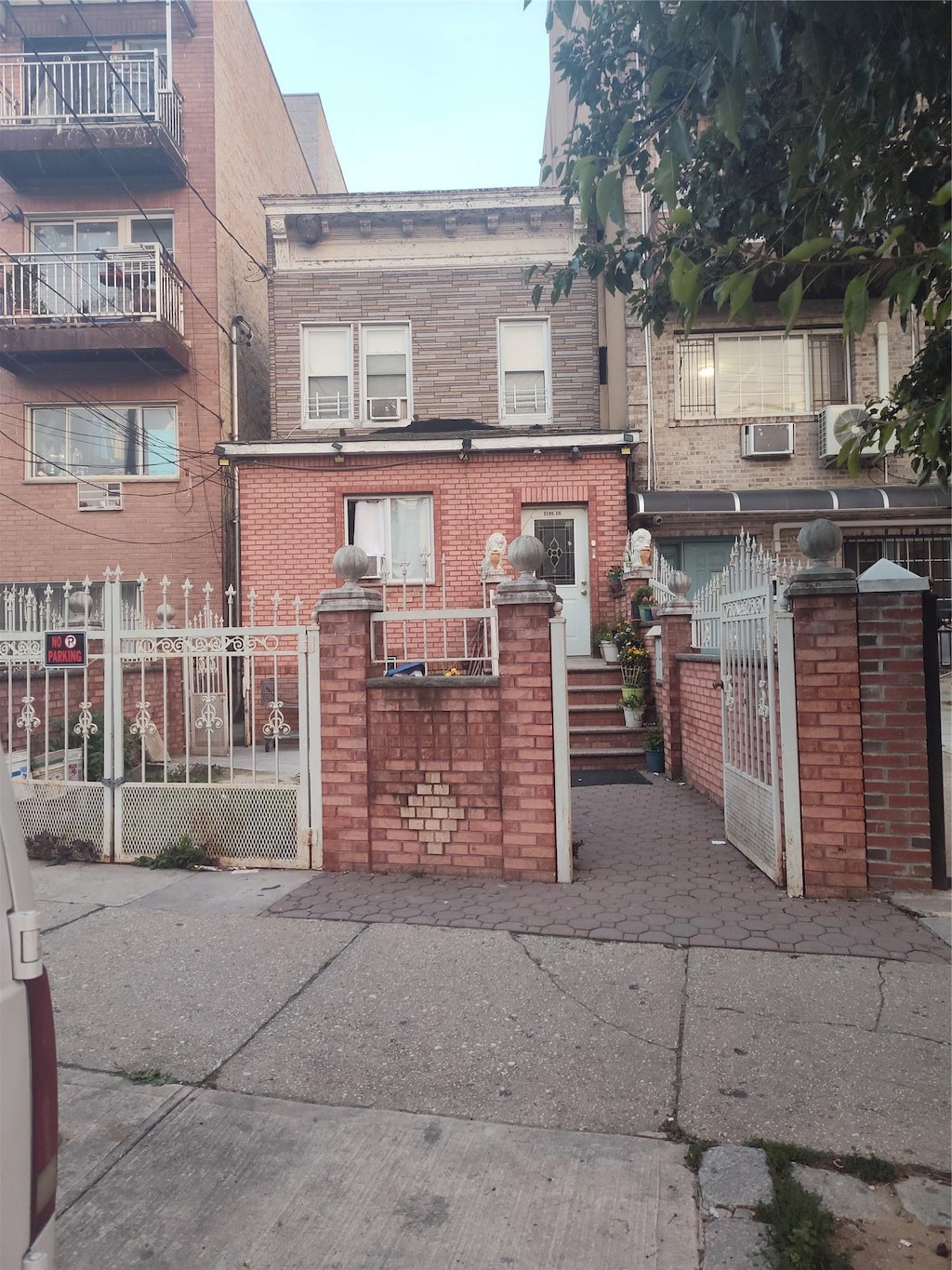 109-16 34th Ave, Corona, NY 11368 - view of front of home featuring a gate, a fenced front yard, and brick siding