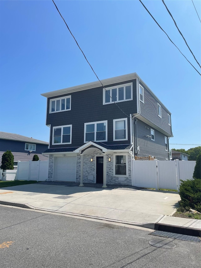 503 Nassau Ave, Freeport, NY 11520 - view of front of home featuring stone siding, driveway, and an attached garage