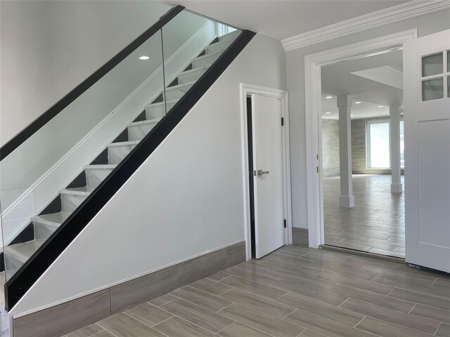 503 Nassau Ave, Freeport, NY 11520 - stairs featuring decorative columns, ornamental molding, and wood tiled floors