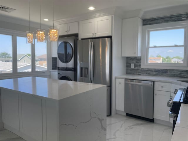 503 Nassau Ave, Freeport, NY 11520 - kitchen with stainless steel appliances, stacked washer / drying machine, healthy amount of natural light, recessed lighting, and light stone counters