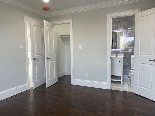 503 Nassau Ave, Freeport, NY 11520 - unfurnished bedroom with dark wood-type flooring, ornamental molding, a spacious closet, a closet, and ensuite bath