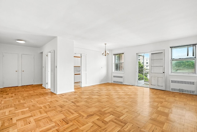 1255 N Ave Unit 2F, New Rochelle, NY 10804 - unfurnished living room featuring radiator heating unit, a chandelier, and plenty of natural light