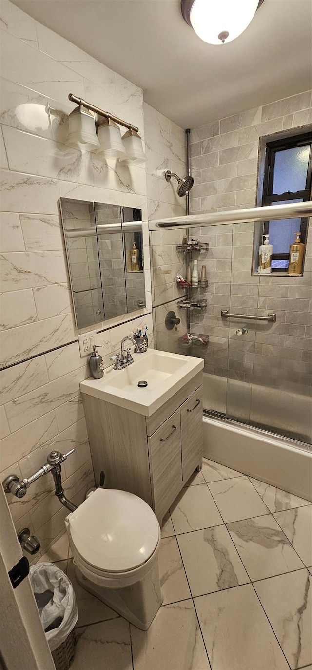 3344 Junction Blvd Unit 2X, Jackson Heights, NY 11372 - full bathroom with vanity, marble finish floors, tile walls, and bath / shower combo with glass door