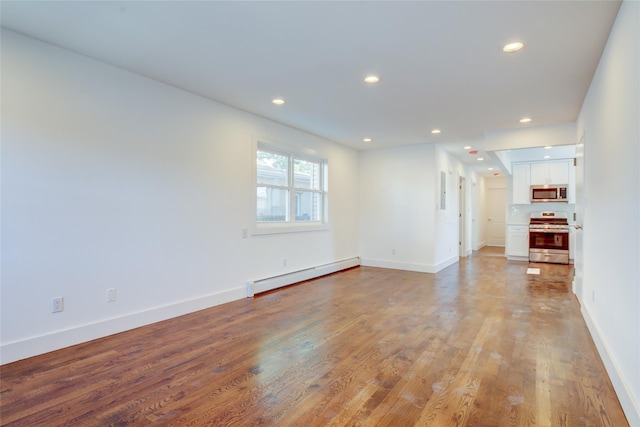 89-25 127th St, Richmond Hill, NY 11418 - unfurnished living room featuring baseboard heating, recessed lighting, and wood finished floors