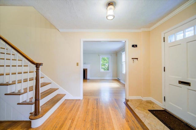 17 Seaman Rd, Poughkeepsie, NY 12601 - entryway featuring stairs, light wood-style floors, crown molding, a fireplace, and a textured ceiling