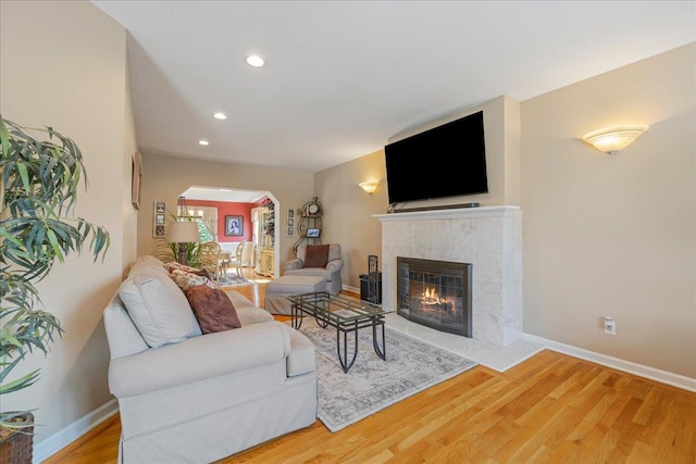 17 Acorn Rd, East Rockaway, NY 11518 - living room with arched walkways, a tiled fireplace, wood finished floors, and recessed lighting