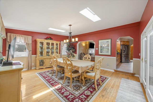 17 Acorn Rd, East Rockaway, NY 11518 - dining area featuring arched walkways, a skylight, and light wood finished floors