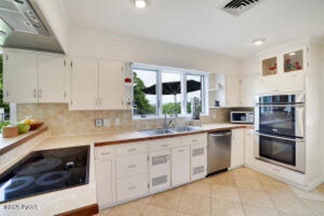 312 E Ann St, Milford, PA 18337 - kitchen with stainless steel appliances, light countertops, white cabinetry, and tasteful backsplash